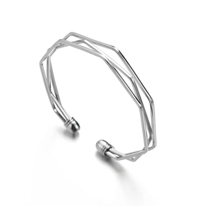 Macro view of geometric multi-layer hollow silver bangle with polished ball ends