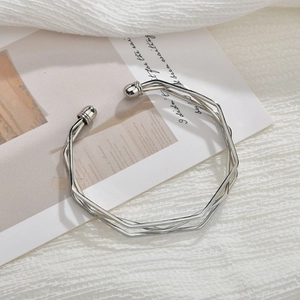 Detail of silver multilayer geometric open bangle with polished round beads and sleek finish