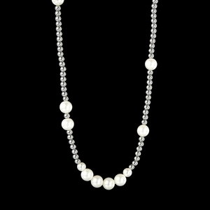 Dettaglio della collana con perle bianche e sfere d'argento con gradiente su sfondo nero