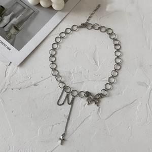 Silver butterfly necklace with cross charms on a white minimalist background