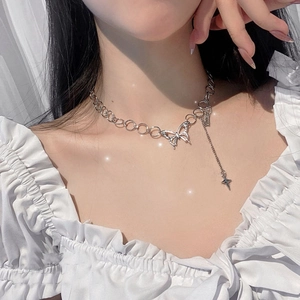 Silver butterfly necklace with ring chain and star tassel pendant worn by female model
