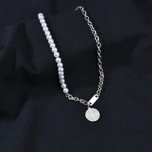 Detail of half pearl and silver chain necklace with a vintage coin relief pendant