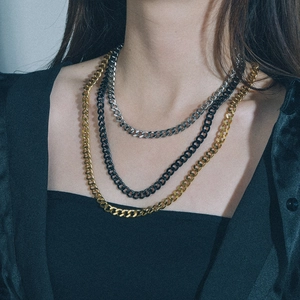 Dreilagige Panzerketten-Halsketten in Gold, Silber und Schwarz, von einem Model getragen