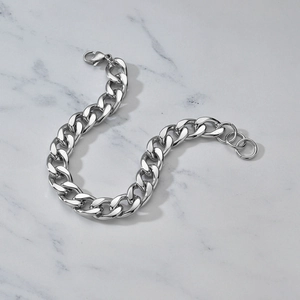 Polished stainless steel chunky curb chain bracelet with lobster clasp on marble