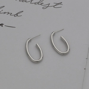 Minimalist silver oval hoop earrings with a polished finish and large C-shape design