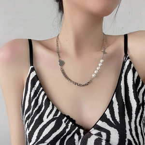 Detail of baroque pearl and silver metal chain necklace with star and heart charms