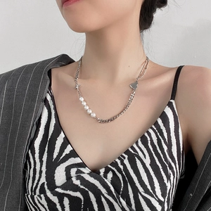 Baroque pearls and silver curb chain necklace with heart and cross charms on model