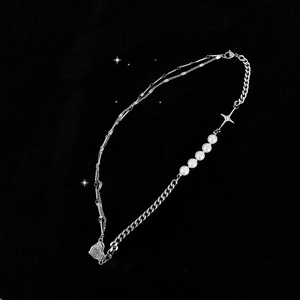 Close-up of asymmetric necklace with baroque pearls and a textured heart pendant