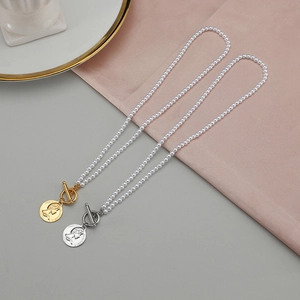 Collier rétro avec pendentif médaillon, perles naturelles et fermoir à bascule en métal