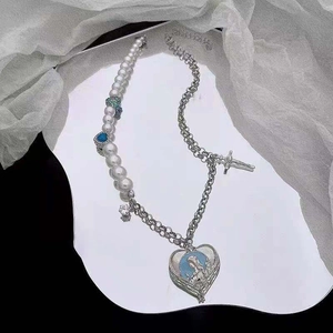Collier chic en perles et chaîne argentée avec pendentif cœur sur surface réfléchissante