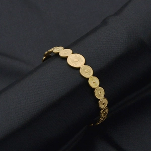 Dettaglio del bracciale aperto in oro 14K con dischi circolari collegati a trama solare