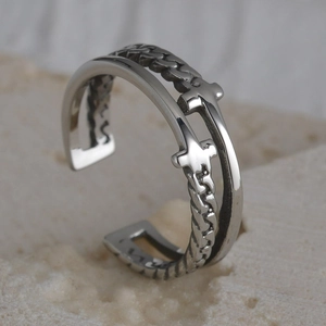 Macro shot of vintage titanium steel ring with chain texture and cross charms