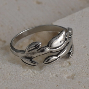 Detailed view of vintage silver leaf-shaped open ring on a textured stone base