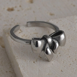 Macro shot of vintage silver bow ring on travertine stone showing antique texture