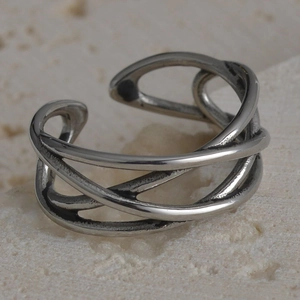 Macro shot of multilayer intertwined vintage steel ring on natural stone texture