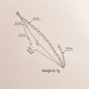 Gros plan du bracelet triple épaisseur en acier avec pendentif soleil et perle