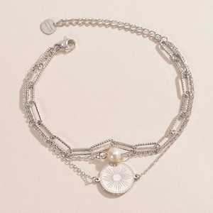 Détail d'un bracelet triple épaisseur en acier inoxydable 316L avec perle et pendentif soleil