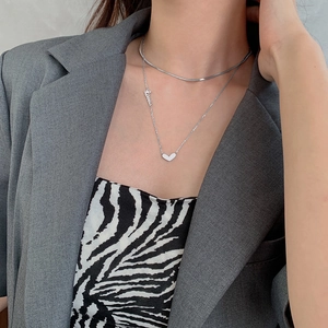 Collier double couche argenté avec pendentif cœur et lettres Love sur un mannequin femme