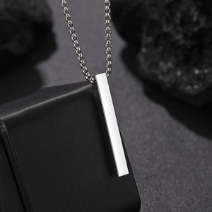Minimalist silver bar pendant necklace with polished box chain on dark textured display