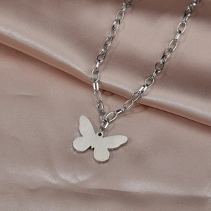 Détail d'un pendentif papillon en argent sur soie montrant la texture du métal brossé