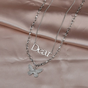 Détail d'un collier double rangée en acier inoxydable avec papillon et lettre Dear