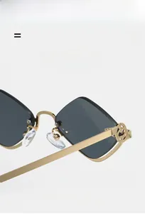 Detail view of gold metal hinges with vintage interlocked luxury logo on dark sunglasses