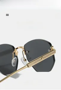 Detailed macro view of rimless polygon sunglasses with golden metal temples and textures