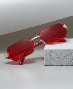 Close-up of frameless red rectangle sunglasses with golden metal bridge and temples