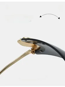 Dettaglio della cerniera in metallo dorato su occhiali da sole senza montura con viti