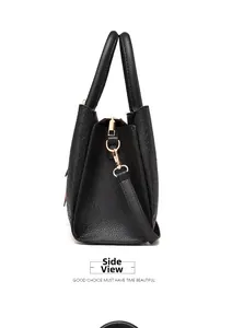 Side view of black embossed leather tote bag with gold metal hardware and detachable strap