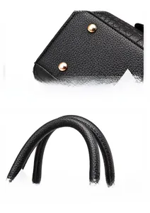 Detail of black crocodile texture handbag with gold metal studs and curved handles