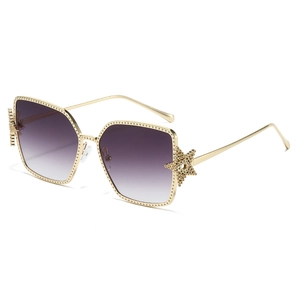 Fashionable golden oversized sunglasses with star-shaped metal detail and gradient lenses