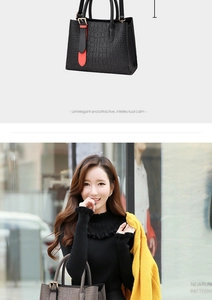 Close-up of embossed crocodile pattern on synthetic leather shoulder bag with gold hardware
