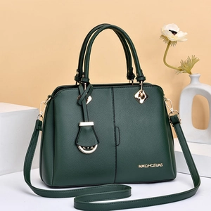 Detail of dark green pebble grain PU leather handbag with gold logo and hardware accents
