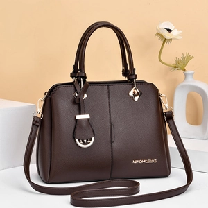 Close-up of dark brown lychee leather bag with gold hardware and logo detail