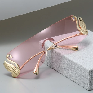 Occhiali da sole rosa senza montatura con cigni dorati e strass su base di pietra