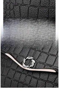 Close-up of black crocodile embossed leather with silver rhinestone buckle detailing