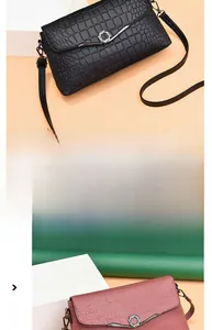 Detail of crocodile pattern crossbody bag featuring a sparkling rhinestone buckle and strap