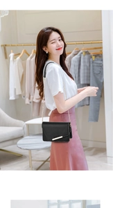 Sac à bandoulière en cuir PU noir avec chaîne porté par un mannequin dans un cadre lifestyle