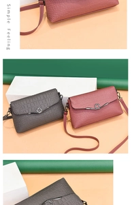 Detail of croco-embossed texture and round metal buckle on crossbody flap bag