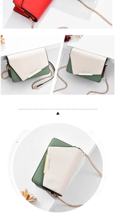Détail du sac bandoulière bicolore avec barre métallique dorée et bandoulière chaîne