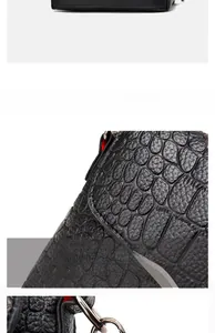 Detailed view of crocodile embossed leather handbag with red lining and metal hardware