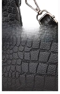 Detail view of black crocodile pattern fabric and detachable metal buckle on the bag
