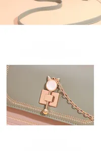 Detail of green leather bag featuring cat-ear gold lock and wheat-ear embroidery pattern