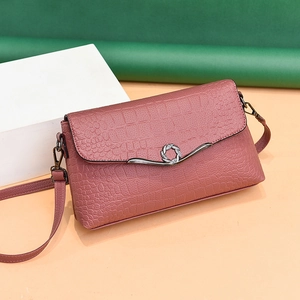 Elegant dusty pink crossbody bag with crocodile embossed leather and metal buckle