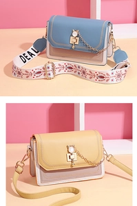 Detail of color-block PU crossbody bag with cat metal lock and wide canvas strap