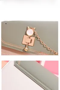 Detail of macaron crossbody bag featuring cat-ear buckle and wavy embroidery patterns
