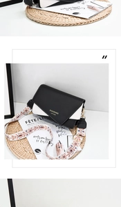 Detail of black and white contrast messenger bag with floral embroidered strap