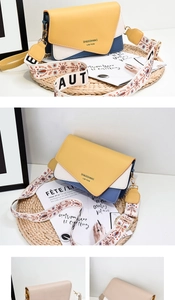 Detail of colorful PU crossbody bag with stylish wide logo strap on a fashion background