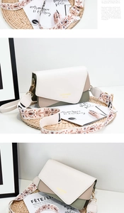 Detail of tricolor square bag with embroidered snowflake strap and gold lettering